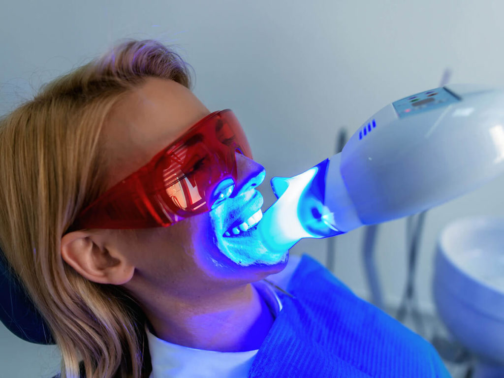 picture of woman getting teeth whitened in dental office