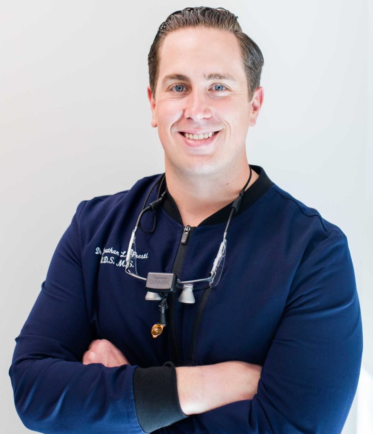 dr jonathan lopresti smiling with arms crossed